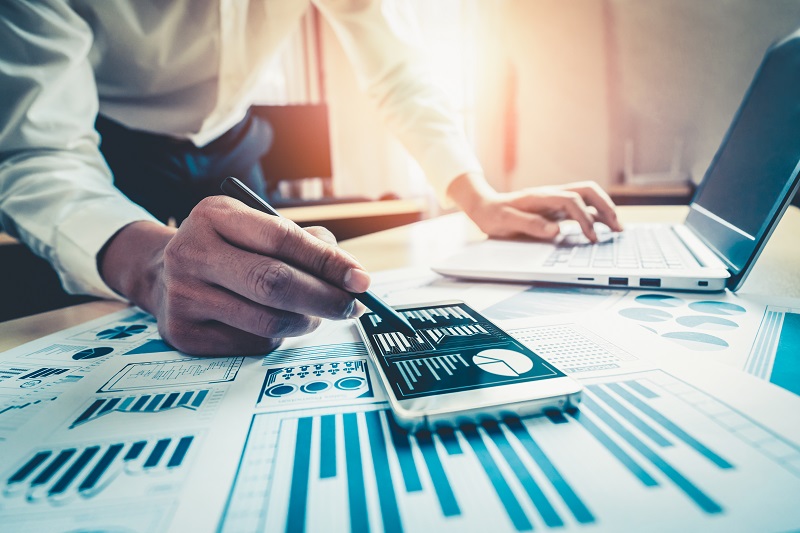 Businessman accountant or financial expert analyze business report graph and finance chart at corporate office. Concept of finance economy, banking business and stock market research.